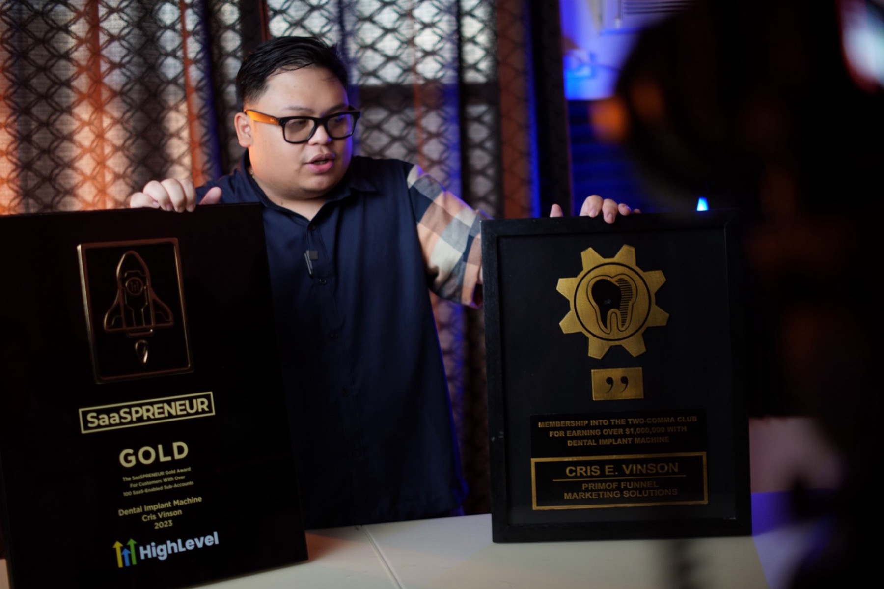Cris Vinson holding his GoHighLevel Gold SaaS and DIM Two Comma Club awards